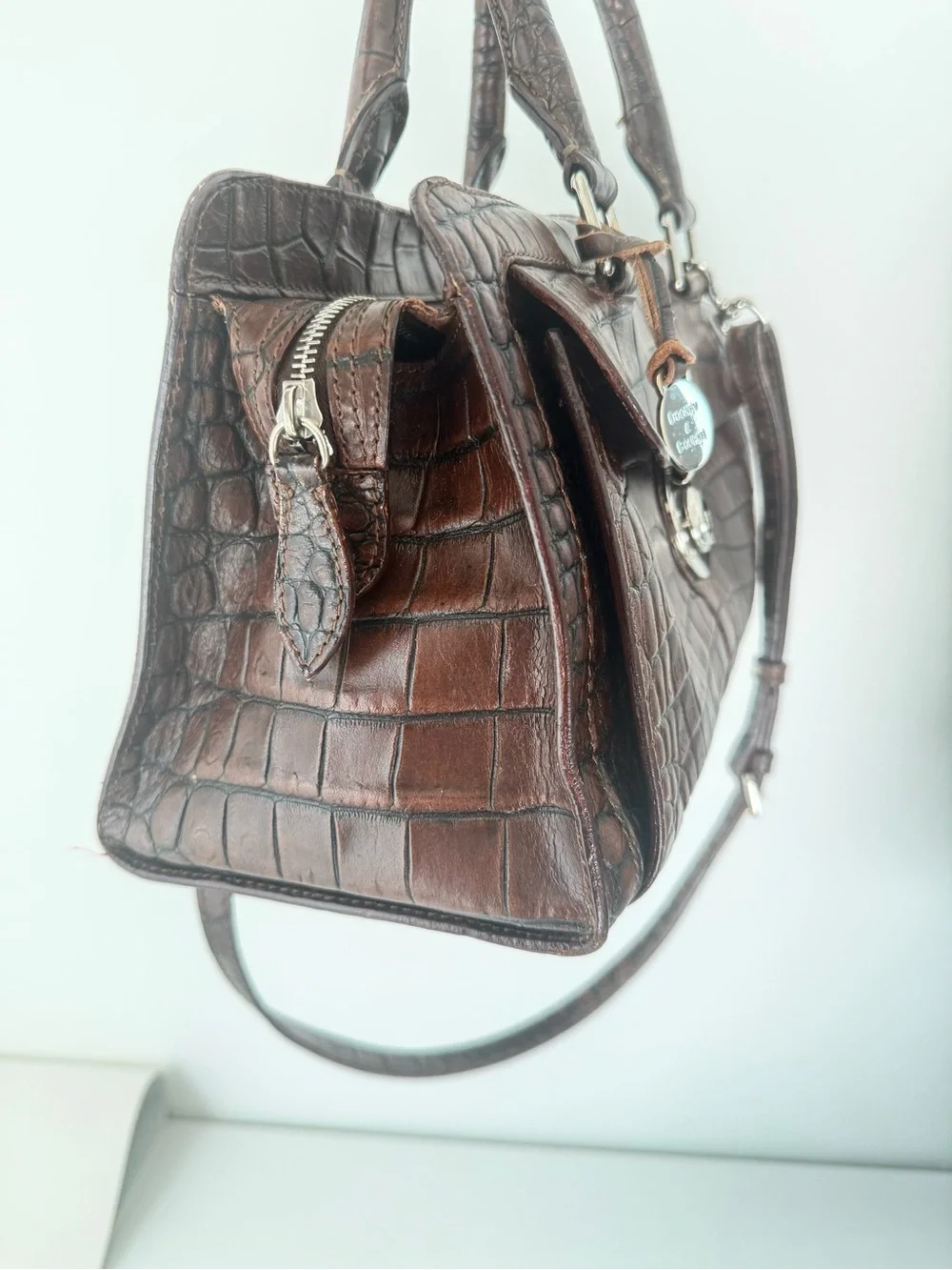 Dooney & Bourke, crafted from rich brown crocodile-embossed leather